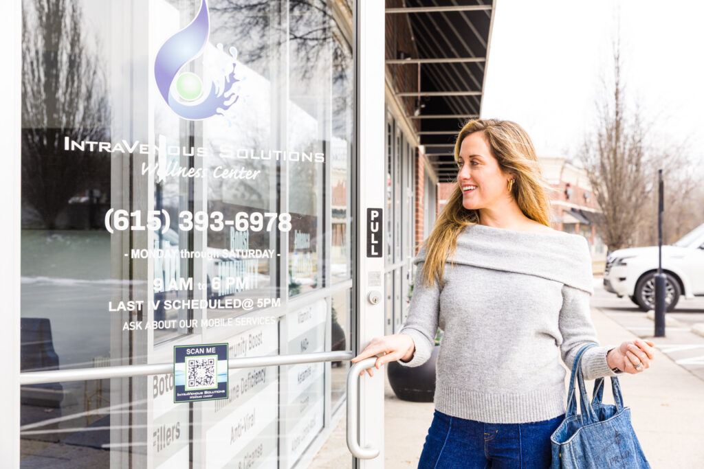 A client smiles as she opens the door to IntraVenous Solutions.