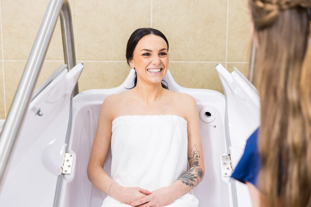 A client in a spa robe smiles as she sits in the HOCATT sauna.
